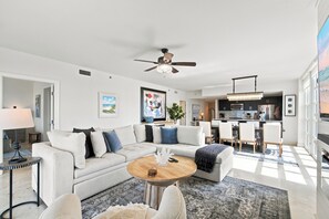 Ein modernes Wohnzimmer mit einer Couch, einem Couchtisch und einem Deckenventilator.
