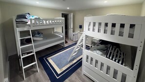 Una habitación con literas, una escalera, un escritorio y una silla.