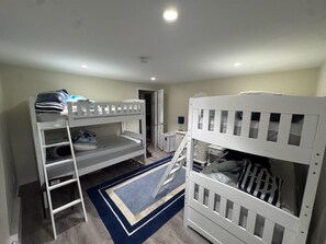 Ein Zimmer mit Etagenbetten, einer Treppe, einem Schreibtisch und einem Stuhl.
