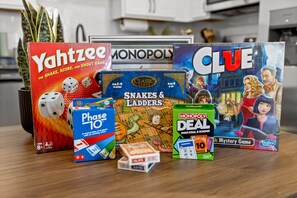 Variedad de juegos de mesa, incluyendo Yahtzee, Monopoly, Clue, Phase 10 y Serpientes y Escaleras.