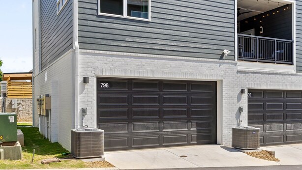 A two-story residential building with a garage and a covered entryway.