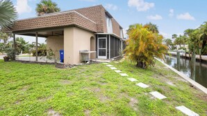 A residential property with a covered patio, a small garden, and a canal. - The Salt House 2 BR / 1.5 BA Canal Front Home by RVA (Longboat Key)