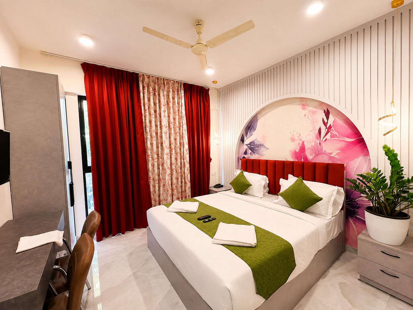 A modern hotel room with a bed, a desk, and a chair.