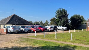 A parking area with multiple cars and a building with a tiled roof. - These quality bungalows are situated 200mt from Hemsby beaches and all ammenties (Gt Yarmouth)