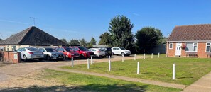 A parking area with multiple cars and a building with a tiled roof. - These quality bungalows are situated 200mt from Hemsby beaches and all ammenties (Gt Yarmouth)