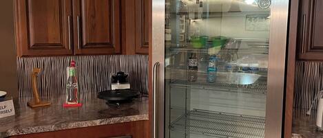 A kitchen with wooden cabinets, a stainless steel refrigerator, and a microwave.