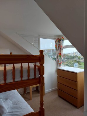 Ein Schlafzimmer mit einem Holzbett, einer Kommode und einem Fenster mit Blick auf die Stadt.