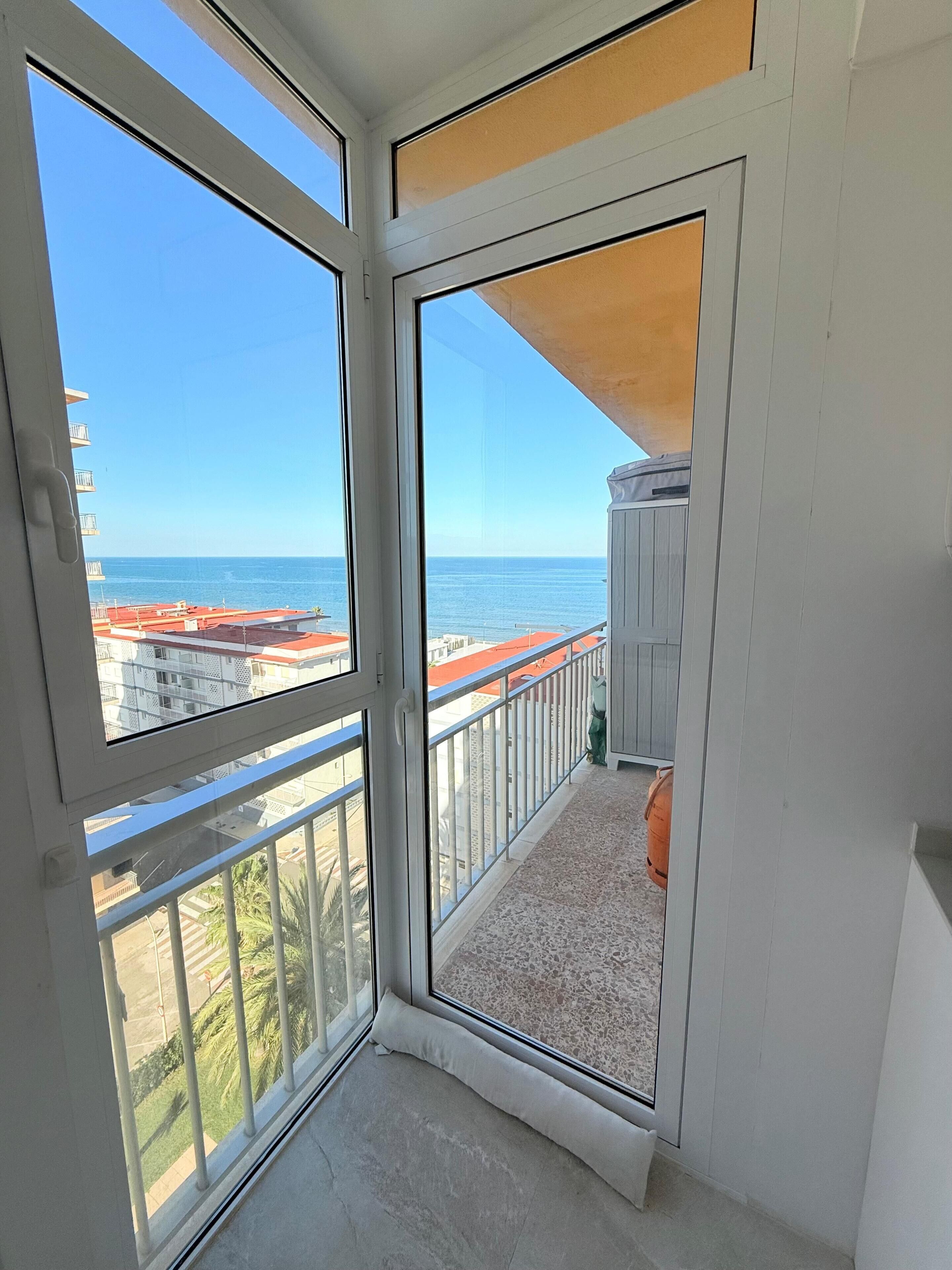 Ein Balkon mit Blick auf das Meer und Gebäude.