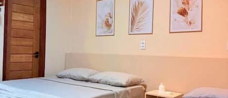 Een slaapkamer met twee bedden, een nachtkastje en kunst aan de muur.