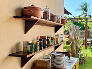 Un estante de cocina con utensilios, frascos y conservas.