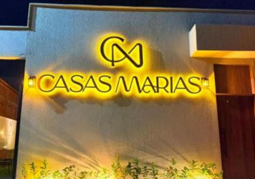 Un edificio con letreros iluminados que dicen 'CASAS MARIAS'.