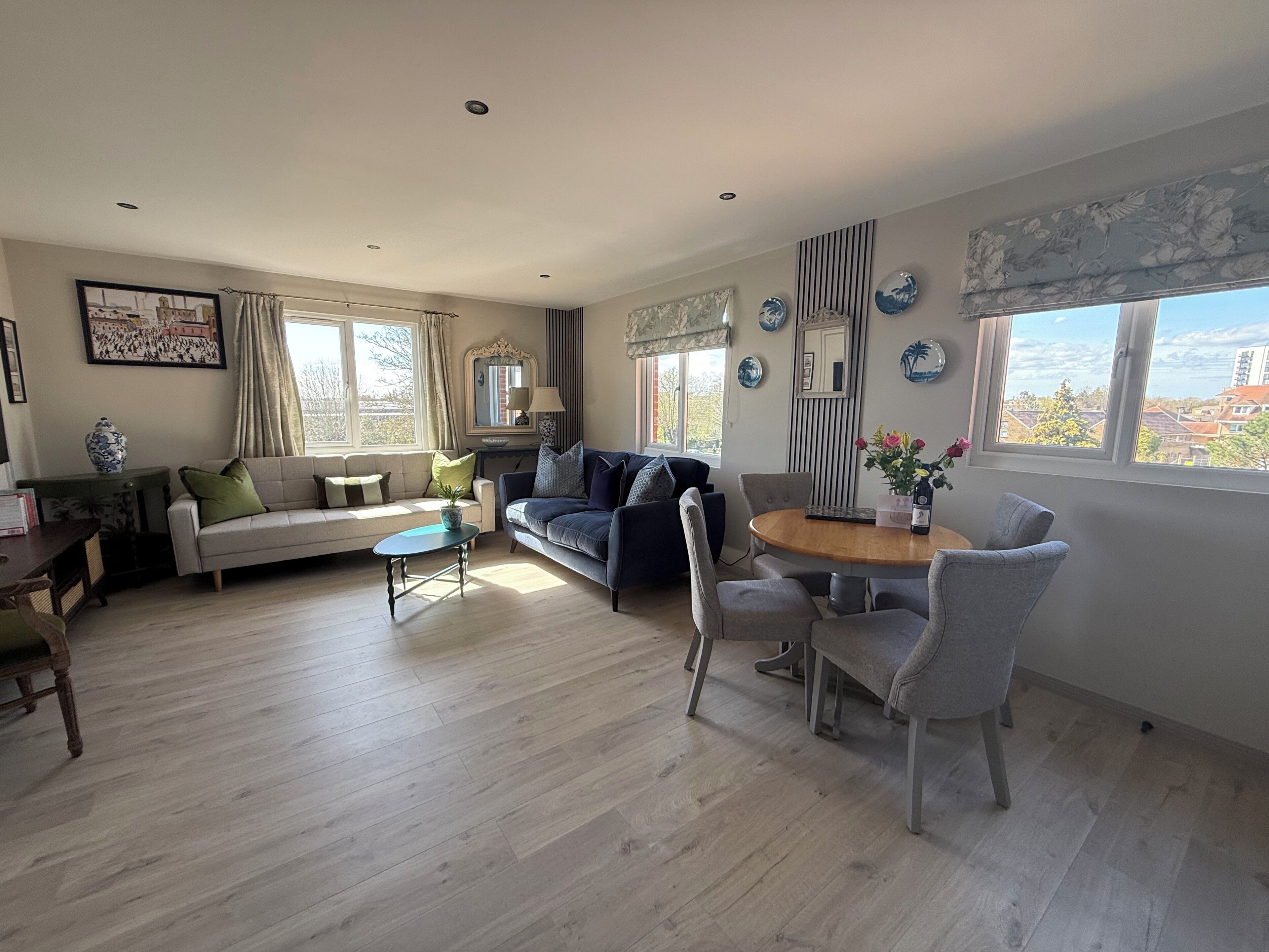 A living room with a sofa, a coffee table, and a dining area with chairs and a table.