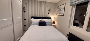 A hotel room with a bed, bedside table, lamp, and a window with a view. -  10mins  drive from Terminal 5 & 35 mins train to London Waterloo (Staines-upon-Thames)