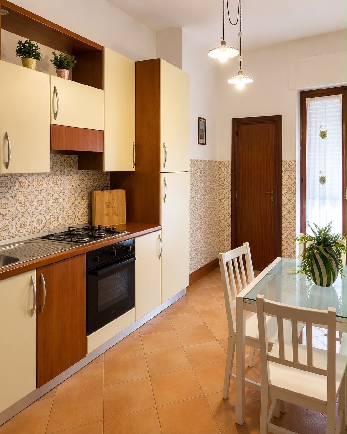 A kitchen with wooden cabinets, a gas stove, and a dining table with chairs.