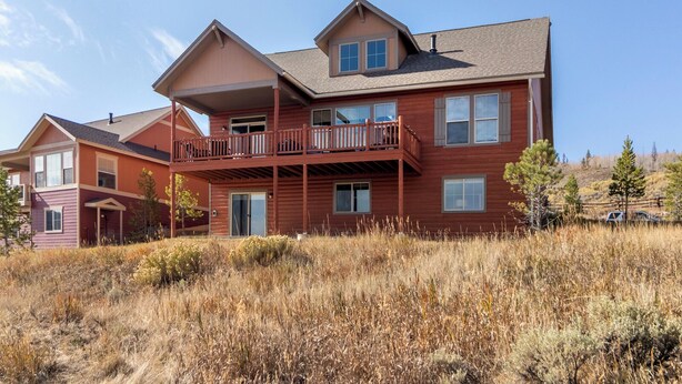A multi-story residential building with a balcony on the second floor and a garage in the front. - Beautiful 4-bedroom house in Granby perfect for your getaway (Granby)