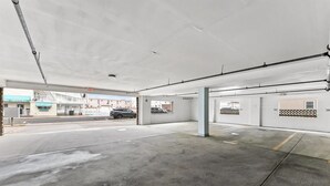 Ett tomt parkeringsgarage med betonggolv och -väggar, några pelare och en tydlig utgångsskylt.