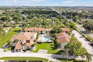 A residential area with multiple houses, a swimming pool, and a road. - Welcoming 2-bedroom apartment with AC in Orlando (Orlando)