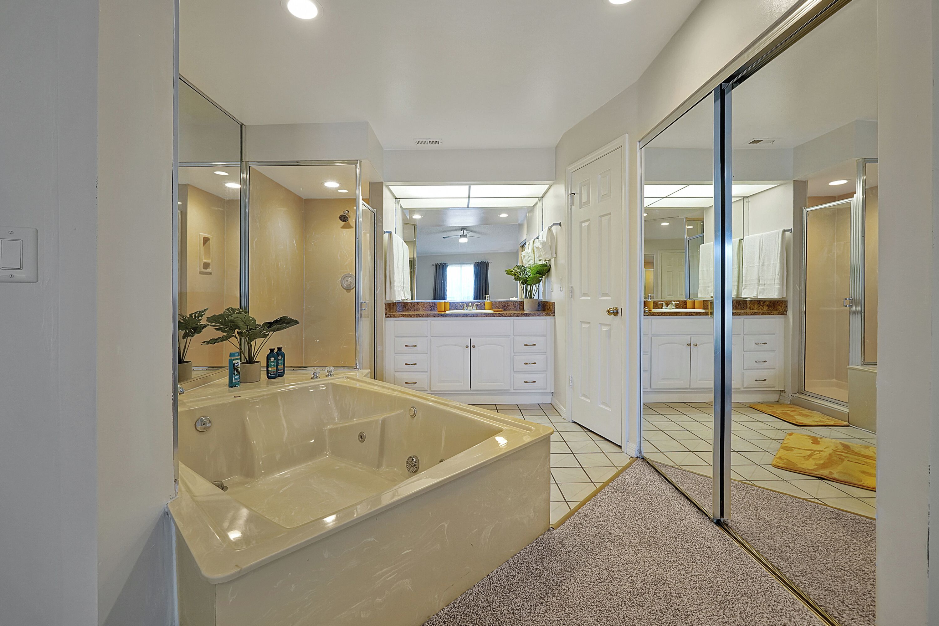 Une salle de bain moderne dotée d’une grande baignoire, d’une douche et d’un meuble-lavabo avec un miroir.