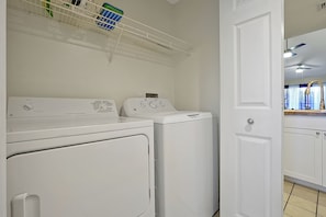 A laundry area with two white washing machines and a white door.