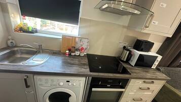 Cocina compacta con lavadora, horno, microondas y lavaplatos.