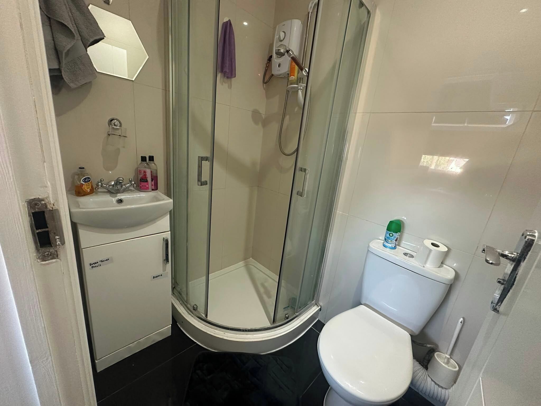 Un baño con ducha de vidrio, inodoro y lavamanos.