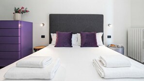 Ein Hotelzimmer mit einem großen Bett, zwei Kissen, einem Schminktisch, einem kleinen Tisch und einer Heizung.