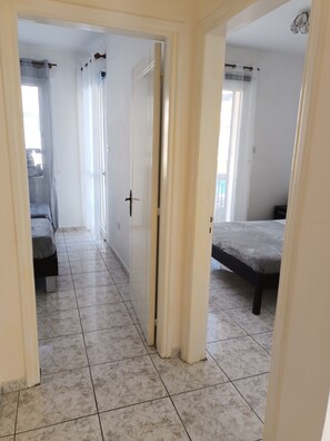 Un pasillo con una cama a la derecha y un armario a la izquierda.