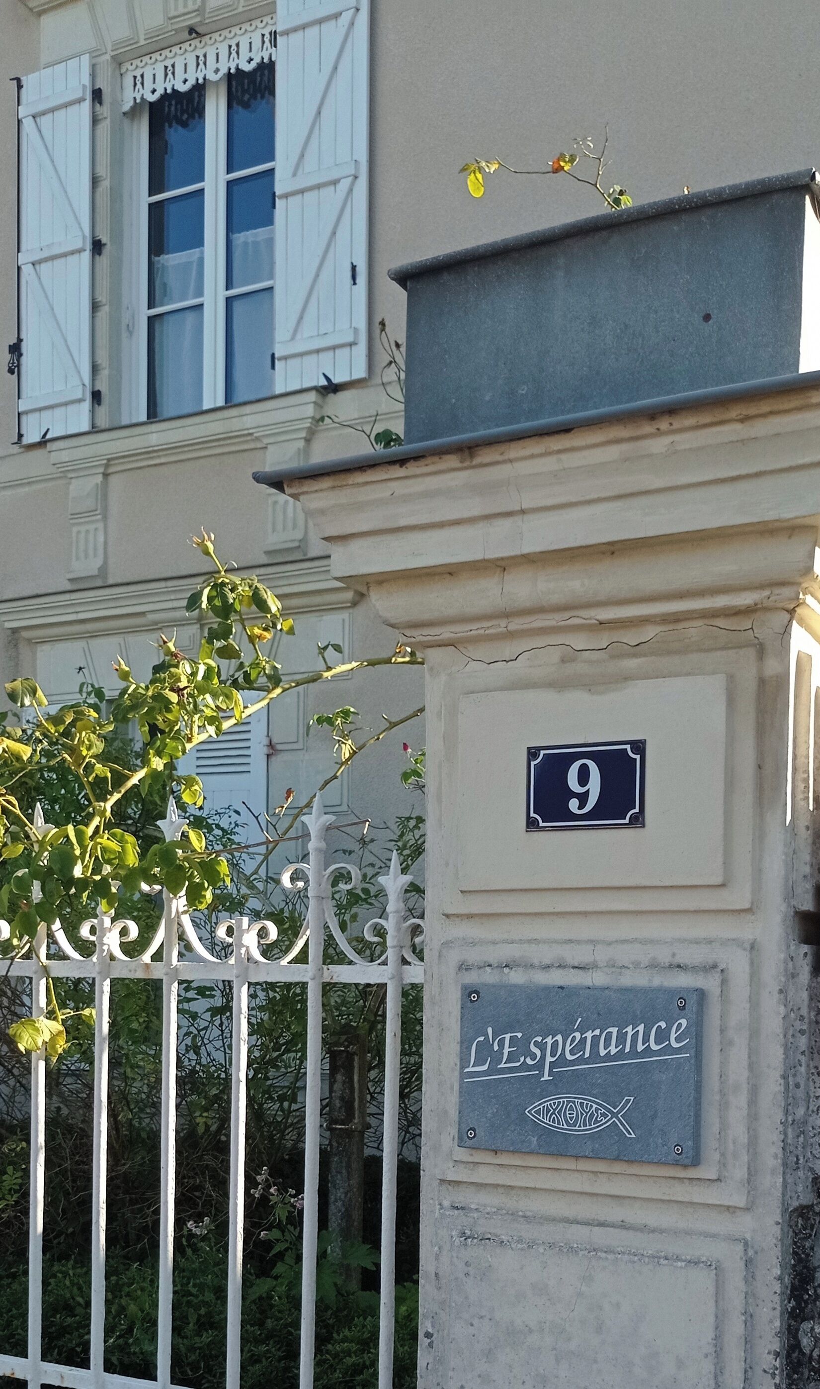 A building facade with a number sign '9' and a plaque with the inscription 'L'Espérance.'