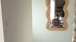 A dining area with a round table, chairs, a mirror, and a potted plant. - Charming vacation rental with a jacuzzi/spa—Anjou (castles), countryside, river, hiking (Étriché)