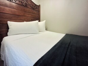 A bed with a wooden headboard, white bedding, and a dark-colored throw blanket. - Sun Harbor Overlook - Sleeps 4 - 1 Bedroom Condo - Waterfront View (Panama City)
