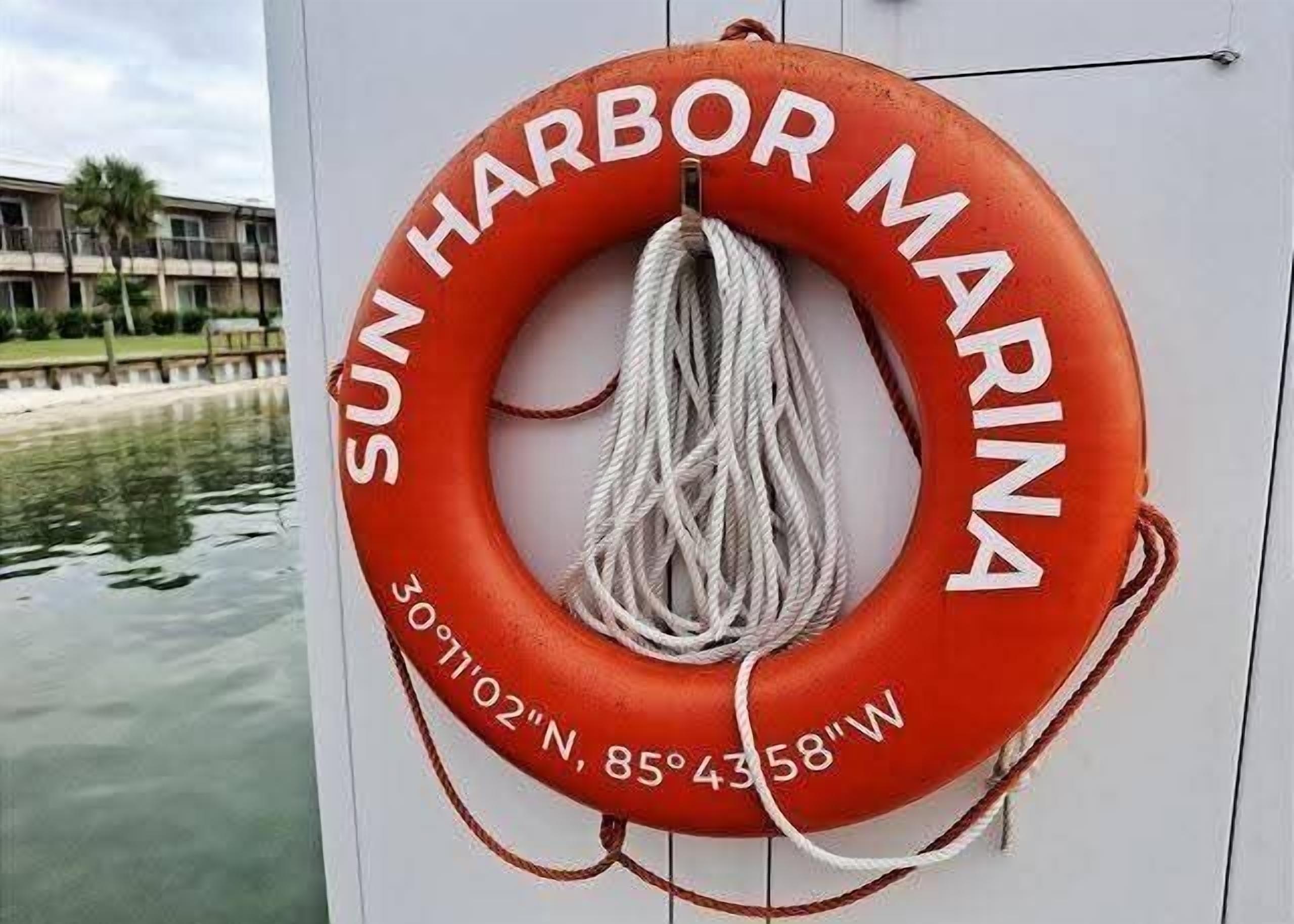 Ein Rettungsboje mit dem Aufdruck 'SUN HARBOR MARINA' und Koordinaten.