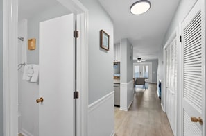 A hallway with white doors, a ceiling light, and a view into a dining area. - Two Bed, Two Bath Townhouse | Sleeps 8 | Community Pool | No Additional Fees (Panama City)