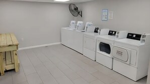 A laundry room with white appliances, a wooden table, and a ceiling fan. - Sun Harbor Serenity - Sleeps 4 - 1 Bedroom Condo Ground Floor Unit (Panama City)