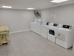 A laundry room with white appliances, a wooden table, and a ceiling fan. - Sun Harbor Serenity - Sleeps 4 - 1 Bedroom Condo Ground Floor Unit (Panama City)