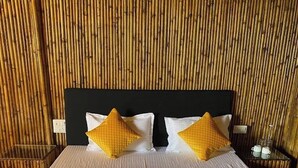 Una cama con cabecera, almohadas y una colcha.
