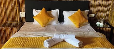 Una cama con cabecera, almohadas y una colcha.