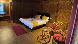 Una habitación con una cama, una mesita y dos sillas.