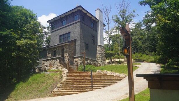 A stone building with a staircase leading to a second floor, surrounded by greenery. - Family friendly castle, 17th century archaic chateau, providing all amenities. (Franklin)