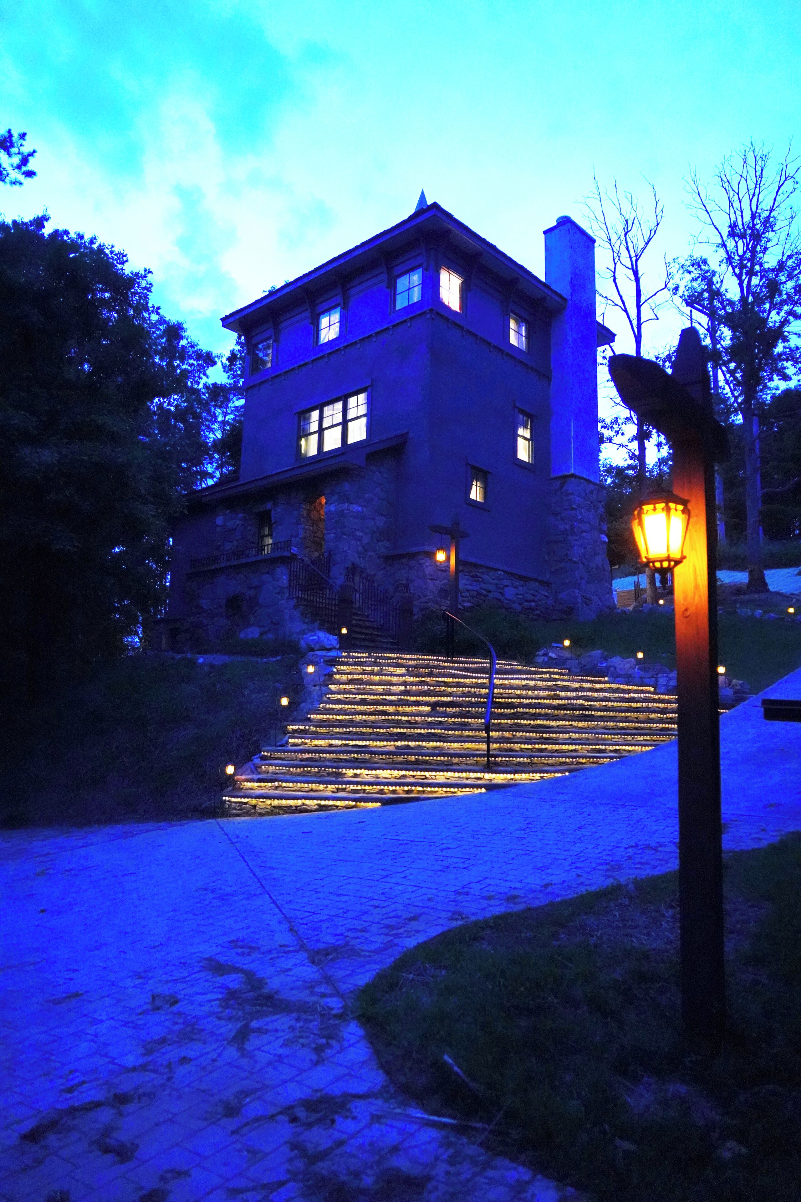 A large stone building with multiple windows and a prominent chimney.