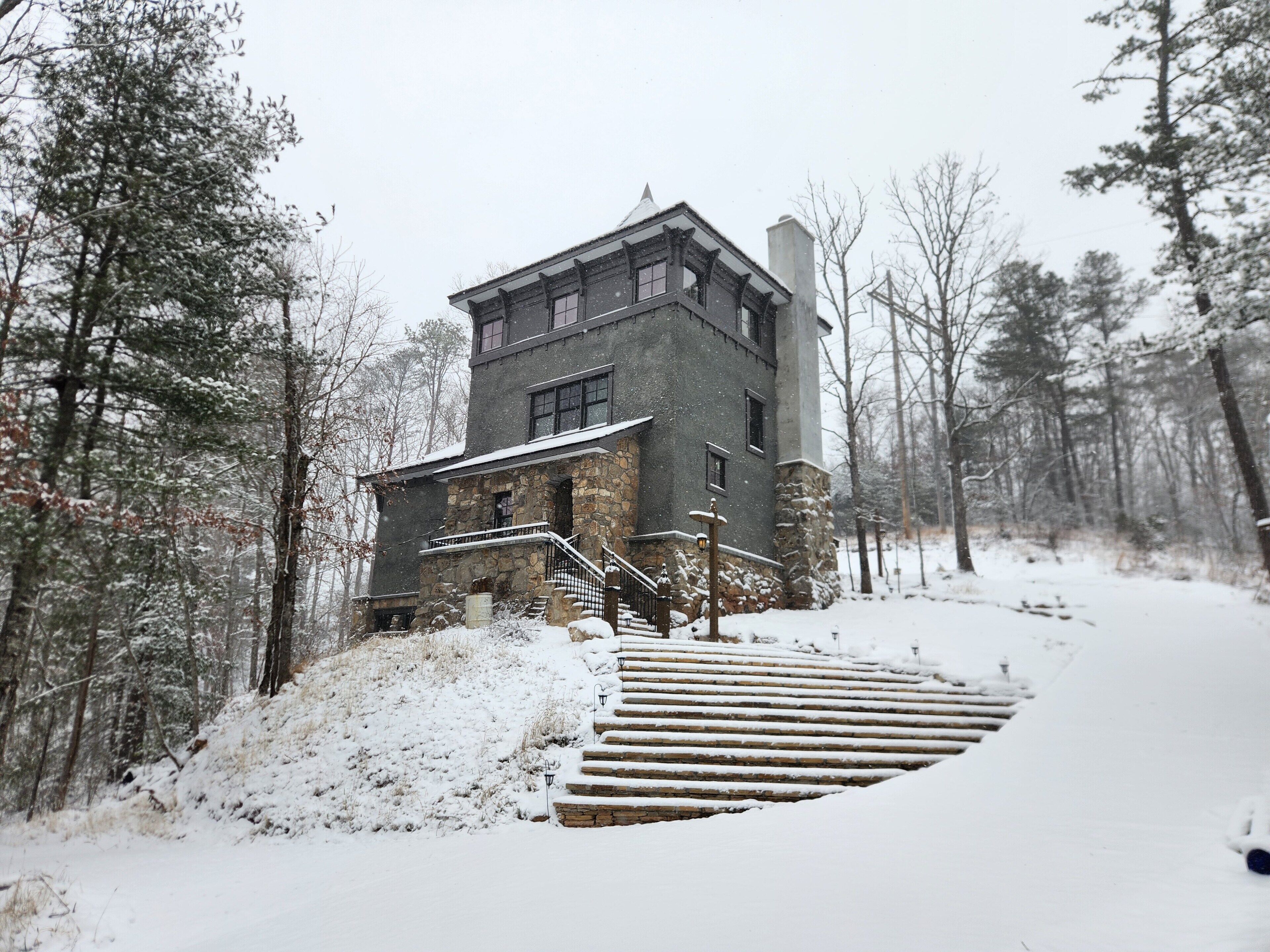 A two-story stone building with a stone staircase leading to the entrance.