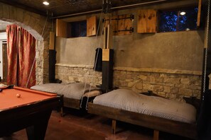 A room with a pool table, two beds, stone walls, and a wooden ceiling. - Family friendly castle, 17th century archaic chateau, providing all amenities. (Franklin)
