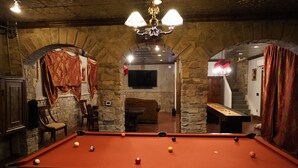 A billiards room with a pool table, stone walls, and a chandelier. - Family friendly castle, 17th century archaic chateau, providing all amenities. (Franklin)