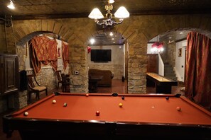 A billiards room with a pool table, stone walls, and a chandelier. - Family friendly castle, 17th century archaic chateau, providing all amenities. (Franklin)