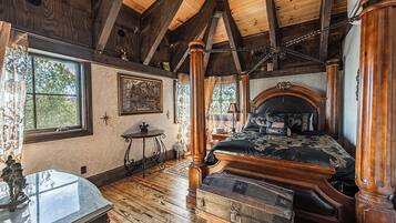 Un dormitorio con una cama grande, vigas de madera, un ventanal y un aparador.