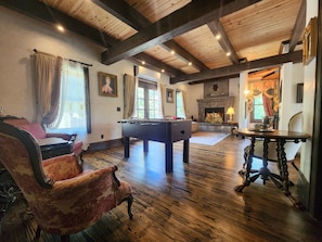 A room with a pool table, a sofa, a chair, and a fireplace. - Family friendly castle, 17th century archaic chateau, providing all amenities. (Franklin)