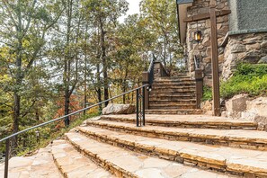 A stone staircase leading to a stone building with a lantern.
