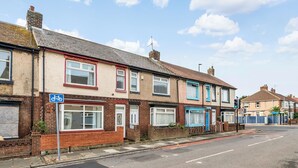 A row of terraced houses with a clear road in front.