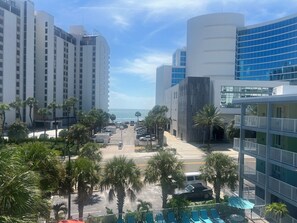 A hotel with multiple floors, a parking lot, and palm trees. - Pelican Pointe 425:Walk to Beach~Pool~Free Parking (Clearwater Beach)