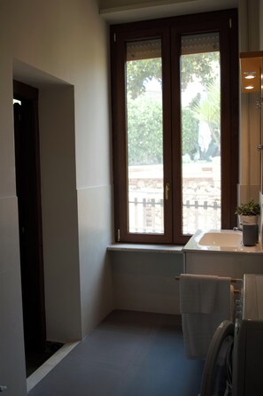 Un bany amb finestra, un lavabo i una barra de tovalloles.