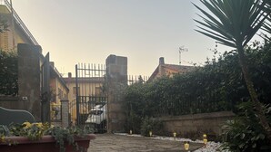 Ein Innenhof mit einer Steintreppe, einer Backsteinmauer und einem Blumentopf.